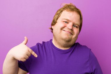 Genç otantik kızıl saçlı şişman adam bir gömlek kopyalama alanı, gurur ve kendinden emin elle işaret