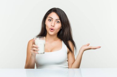 Elinde bir bardak süt tutan genç İspanyol kadın, avuç içinin fotokopisini çekerken çok etkilendi..