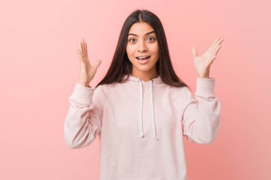 Spor giyinmiş genç, güzel bir Arap kadın hoş bir sürpriz bekliyor, heyecanlı ve el kaldırıyor..