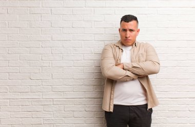 Kollarını kavuşturan genç Latin adam rahatladı.