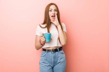 Kafkasyalı bir kadın elinde fincanla heyecanla bağırıyor..