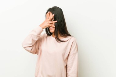 Genç, tatlı İspanyol kadın kameraya parmaklarıyla göz kırpıyor, utanarak yüzünü kapatıyor..