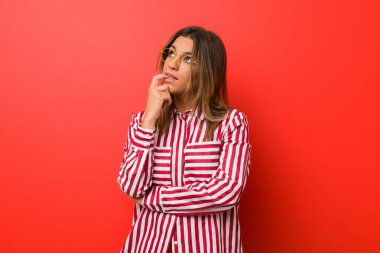 Bir duvara karşı Genç otantik karizmatik gerçek insanlar kadın bir şey hakkında bir kopyasını alana bakarak düşünme rahat.