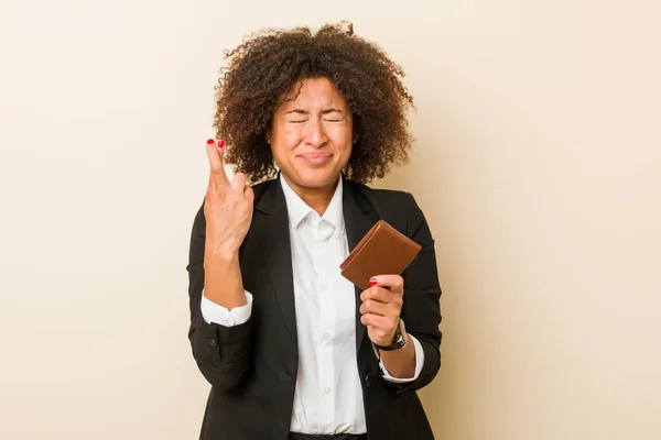 若いアフリカ系アメリカ人の女性は幸運を持っているために指を横断財布を保持 — ストック写真