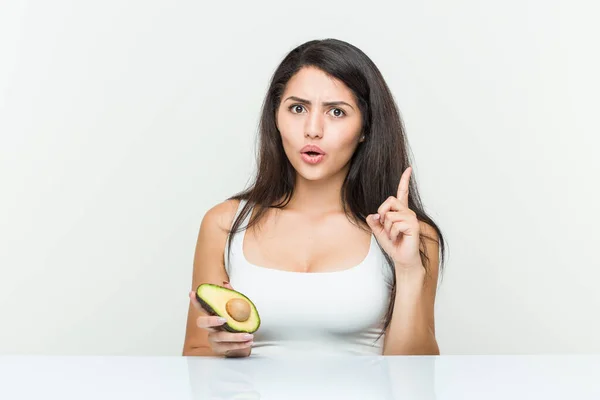 Joven Mujer Hispana Sosteniendo Aguacate Teniendo Alguna Gran Idea Concepto —  Fotos de Stock