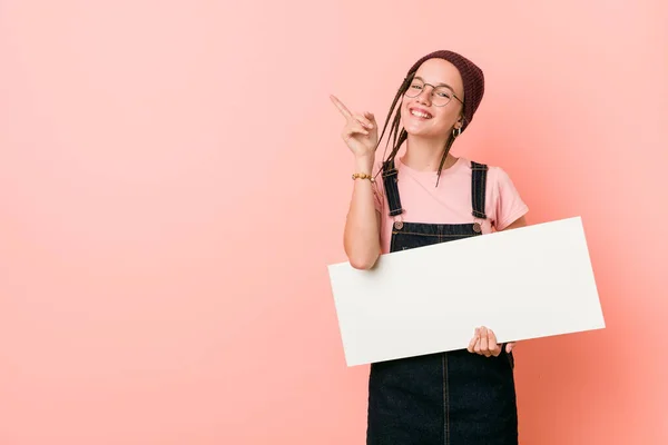 Joven Mujer Caucásica Sosteniendo Cartel Sonriendo Alegremente Señalando Con Dedo —  Fotos de Stock