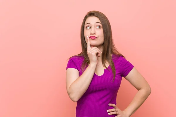 Young Hispanic Woman Pink Wall Looking Sideways Doubtful Skeptical Expression — Stock Photo, Image
