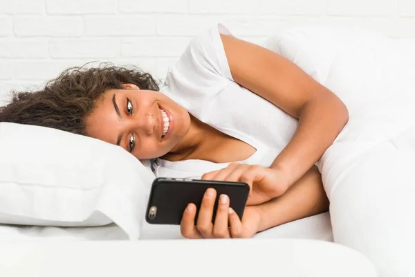 Młody African American Kobieta Leżąc Łóżku Pisanie Wiadomości Tekstowej — Zdjęcie stockowe