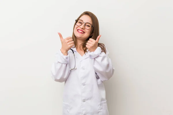 Joven Doctora Contra Una Pared Blanca Levantando Ambos Pulgares Hacia — Foto de Stock