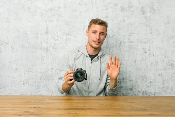 Jeune Photographe Tenant Une Caméra Sur Une Table Rejetant Quelqu — Photo