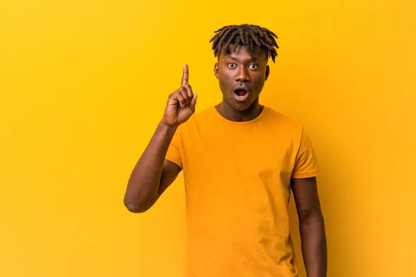 Young black man wearing rastas over yellow background having some great idea, concept of creativity.