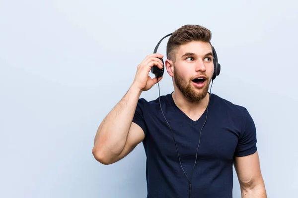 Giovane Uomo Caucasico Che Ascolta Musica Cercando Ascoltare Pettegolezzo — Foto Stock