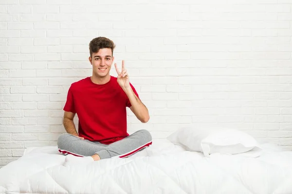 Yatakta Iki Numarayı Parmaklarıyla Gösteren Genç Öğrenci — Stok fotoğraf