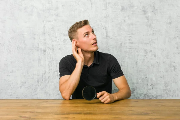 Ung Stilig Man Som Håller Ett Förstoringsglas Och Försöker Lyssna — Stockfoto