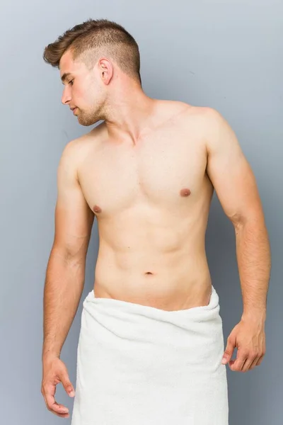 Young caucasian man shirtless wearing a towel — Stock Photo, Image