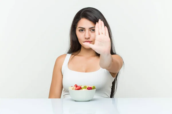 Jovem Hispânica Comendo Uma Tigela Frutas Com Mão Estendida Mostrando — Fotografia de Stock