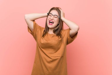 Gözlük takan genç öğrenci kadın ellerini başının üstünde tutarak neşe içinde gülüyor. Mutluluk kavramı.