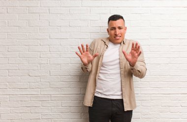 Genç Latin adam iğrenme hareketi yaparak bir şeyi reddediyor.