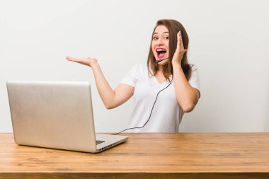 Genç pazarlamacı kadın avuç içinde fotokopi makinesi tutuyor, el üstünde tutuyor. Şaşırmış ve mutlu..