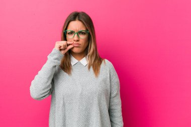 Dudaklarında parmakları ile bir duvara karşı genç otantik karizmatik gerçek insanlar kadın bir sır tutmak.