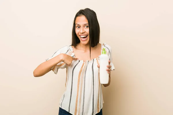 Junge Hispanische Frau Mit Einer Cremeflasche Überrascht Zeigt Auf Sich — Stockfoto
