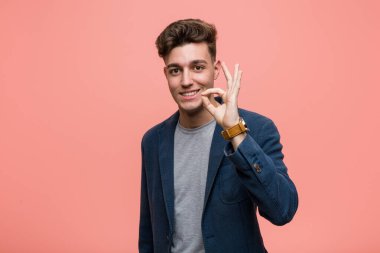 Genç iş adamı. Neşeli ve kendinden emin. İyi bir jest yapıyor..