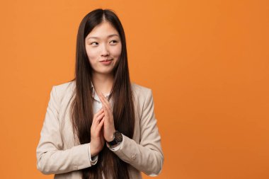 Young business chinese woman making up plan in mind, setting up an idea.