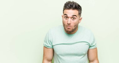 Yeşil bir geçmişi olan genç yakışıklı bir adam omuzlarını silker ve gözleri açık kalır..