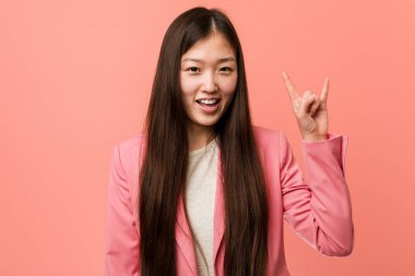 Pembe takım elbiseli genç Çinli kadın boynuzlarını devrim konsepti olarak gösteriyor..