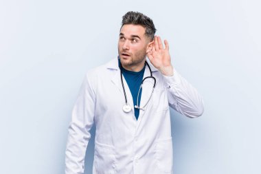 Dedikoduları dinlemeye çalışan yakışıklı bir doktor..