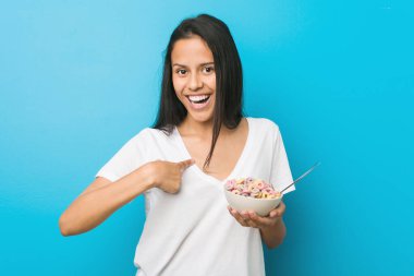 Şeker kasesi tutan genç İspanyol kadın kendini işaret ederek şaşırdı, geniş bir gülümsemeyle..