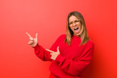 Genç otantik karizmatik gerçek insanlar kadın bir duvara karşı bir kopya alanı için işaret eden, heyecan ve arzu ifade.