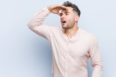 Genç yakışıklı havalı adam uzaklara bakıyor ve elini alnına koyuyor..