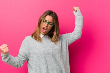 Bir zafer, kazanan kavramı sonra yumruk yükselterek bir duvara karşı Genç otantik karizmatik gerçek insanlar kadın.