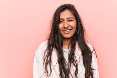 Genç Hintli kadın pijama giyiyor, göz kırpıyor, komik, arkadaş canlısı ve kaygısız.