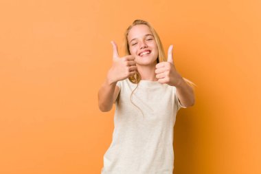 Başparmak ups ile Sevimli ve doğal genç kadın, bir şey hakkında tezahürat, destek ve saygı kavramı.