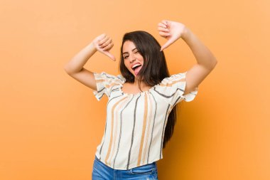 Genç kıvrımlı kadın baş parmağını aşağı gösteriyor ve hoşlanmadığını ifade ediyor..