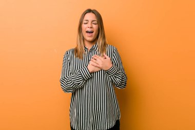 Genç otantik karizmatik gerçek insanlar kadın bir duvara karşı gülerek kalp, mutluluk kavramı ellerini tutarak.