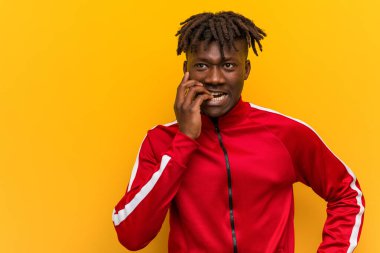 Tırnak yiyen genç fitness Afrikalı adam, gergin ve çok endişeli..