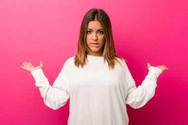 Bir duvara karşı genç otantik karizmatik gerçek insanlar kadın karışık ve şüpheli omuzsilkleme omuzlar bir kopyasını alanı tutmak için.