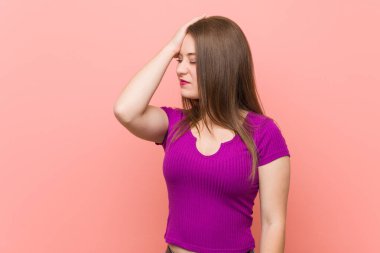 Genç İspanyol kadın pembe bir duvara yaslanmış bir şeyi unutuyor. Alnına avuç içi ve gözlerini kapatıyor..