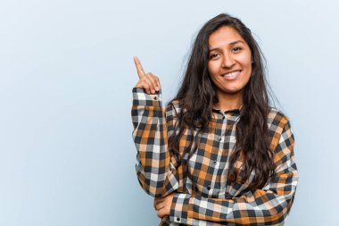 Genç, havalı Hintli kadın işaret parmağıyla işaret ederek gülümsüyor..