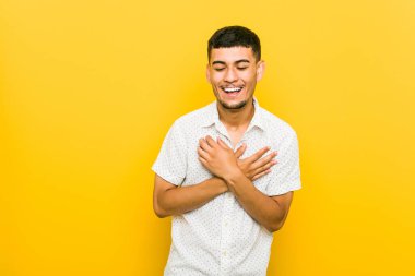 Genç İspanyol adam kalp, mutluluk kavramı ellerini tutarak gülüyor.