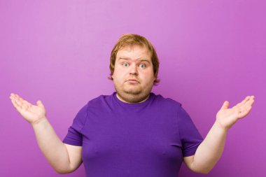 Genç otantik kızıl saçlı şişman adam hoş bir sürpriz alıyor, heyecanlı ve el kaldırıyor..