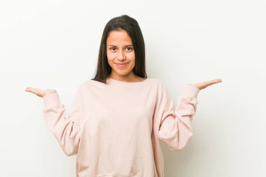 Genç, tatlı İspanyol kadın kollarıyla ölçü yapıyor, mutlu ve kendinden emin..