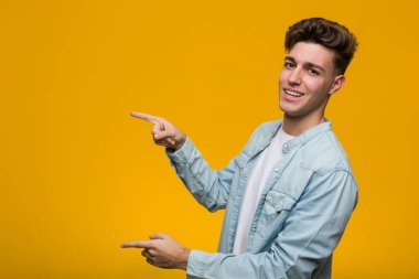 Kot gömlek giyen genç ve yakışıklı bir öğrenci işaret parmağıyla işaret ediyor..