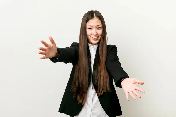 Young pretty chinese business woman feels confident giving a hug to the camera.