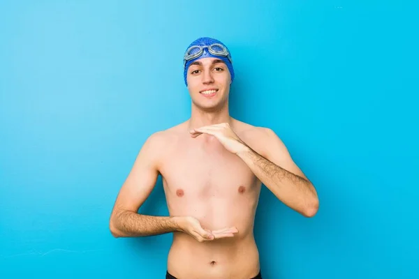 Junger Schwimmer Hält Etwas Mit Beiden Händen Produktpräsentation — Stockfoto