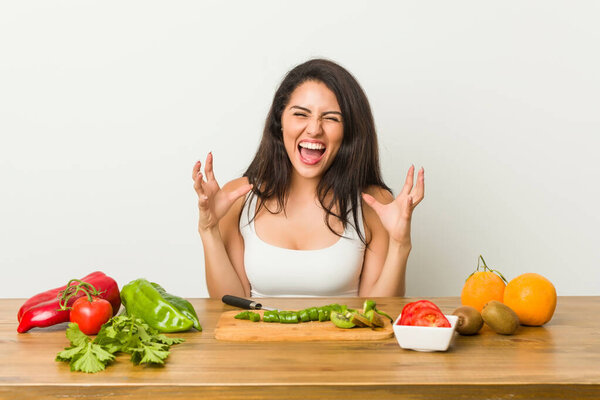 Молодая пышная женщина готовит здоровую еду крича от ярости
.