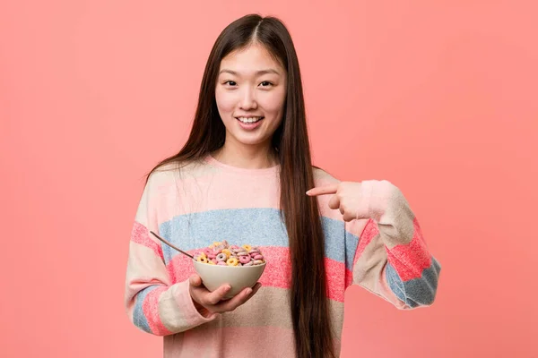 Jonge Aziatische Vrouw Met Een Cornflakes Kom Verrast Wijzend Naar — Stockfoto